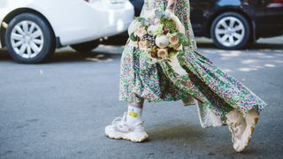 Bride crossing the street in floral dress and trainers