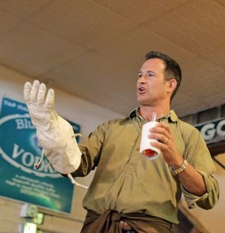 Dogfish Head founder Sam Calagione compares an ILC spacesuit glove to Celest-jewel-ale's spacesuit koozie.