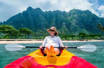 A woman suns herself on a kayak.