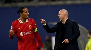 LEIPZIG, GERMANY - OCTOBER 23: (THE SUN OUT, THE SUN ON SUNDAY OUT) Arne Slot head coach of Liverpool talking with Virgil van Dijk captain of Liverpool during the UEFA Champions League 2024/25 League Phase MD3 match between RB Leipzig and Liverpool FC at Leipzig Stadium on October 23, 2024 in Leipzig, Germany. (Photo by Andrew Powell/Liverpool FC via Getty Images)