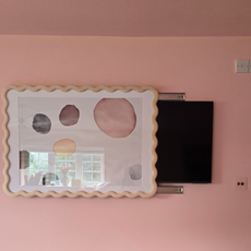 The completed frame hack showing the Habitat wav frame covering half a wall-mounted tv.