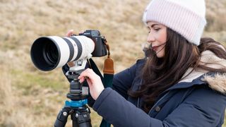 woman setting up a camera on a tripod