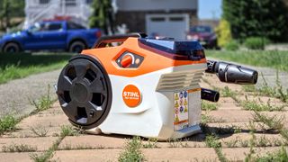 Stihl REA 100 Plus on pavers with weeds all around it.