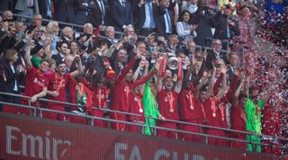 LONDON, ENGLAND - MAY 14: Liverpool capatin Jordan Henderson lifts the FA Cup as his team mates celebrate winning the The FA Cup Final match between Chelsea and Liverpool at Wembley Stadium on May 14, 2022 in London, England. (Photo by Visionhaus//Getty Images)
