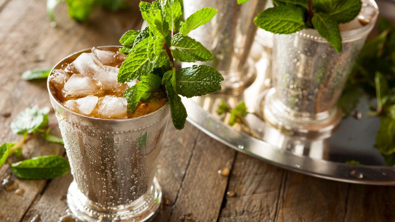 Mint julep cocktail with lots of ice sitting on a table