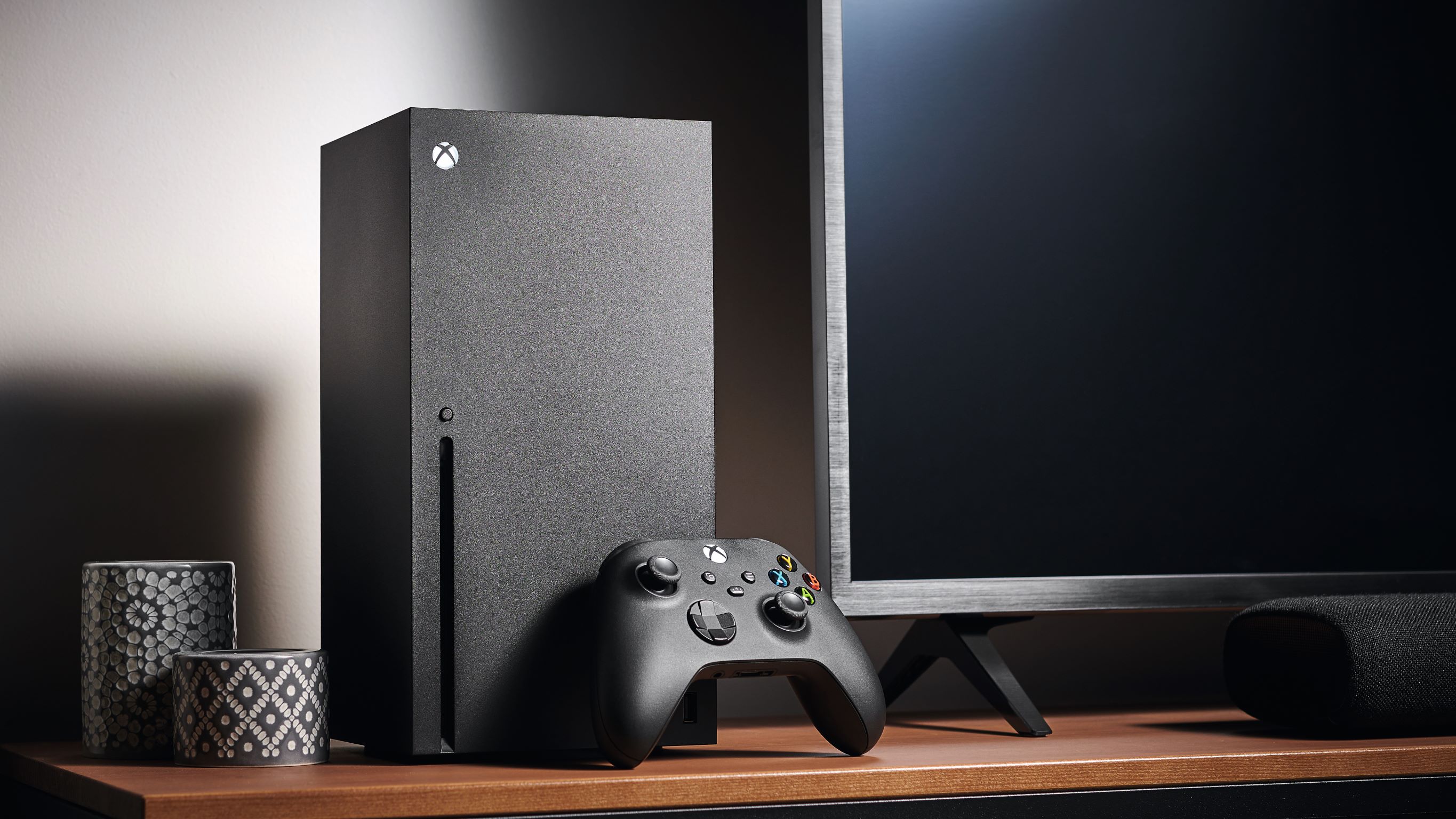 An Xbox Series X and a Controller on a TV stand