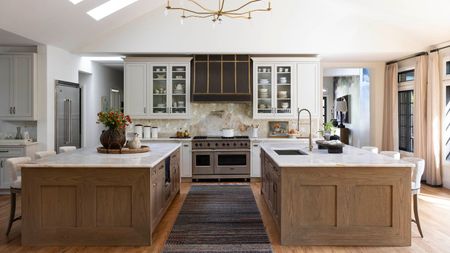 White kitchen with two wooden islands and a gray runner in between