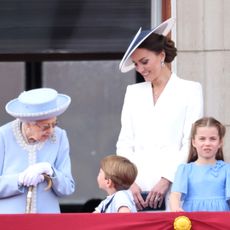 Queen Elizabeth talking to Prince Louis on the palace balcony as Princess Kate, Prince William, Princess Charlotte and Prince George look on