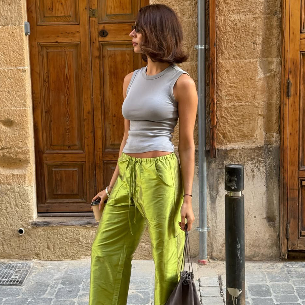 Woman in a gray tank and green silk taffeta pants