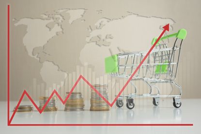 Small shopping cart with stacked coins and growth graph. 