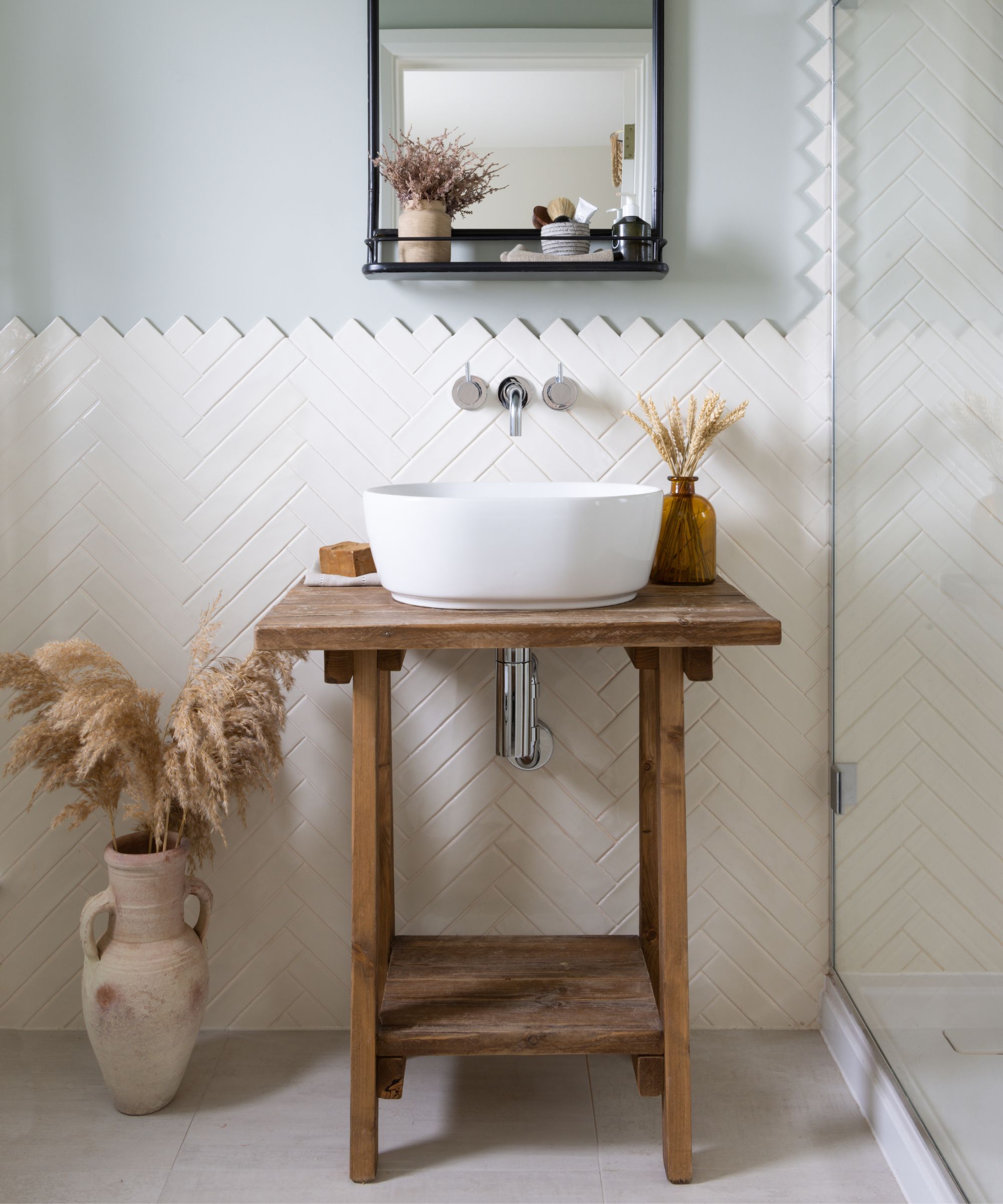A small bathroom with a wooden vanity featuring open storage