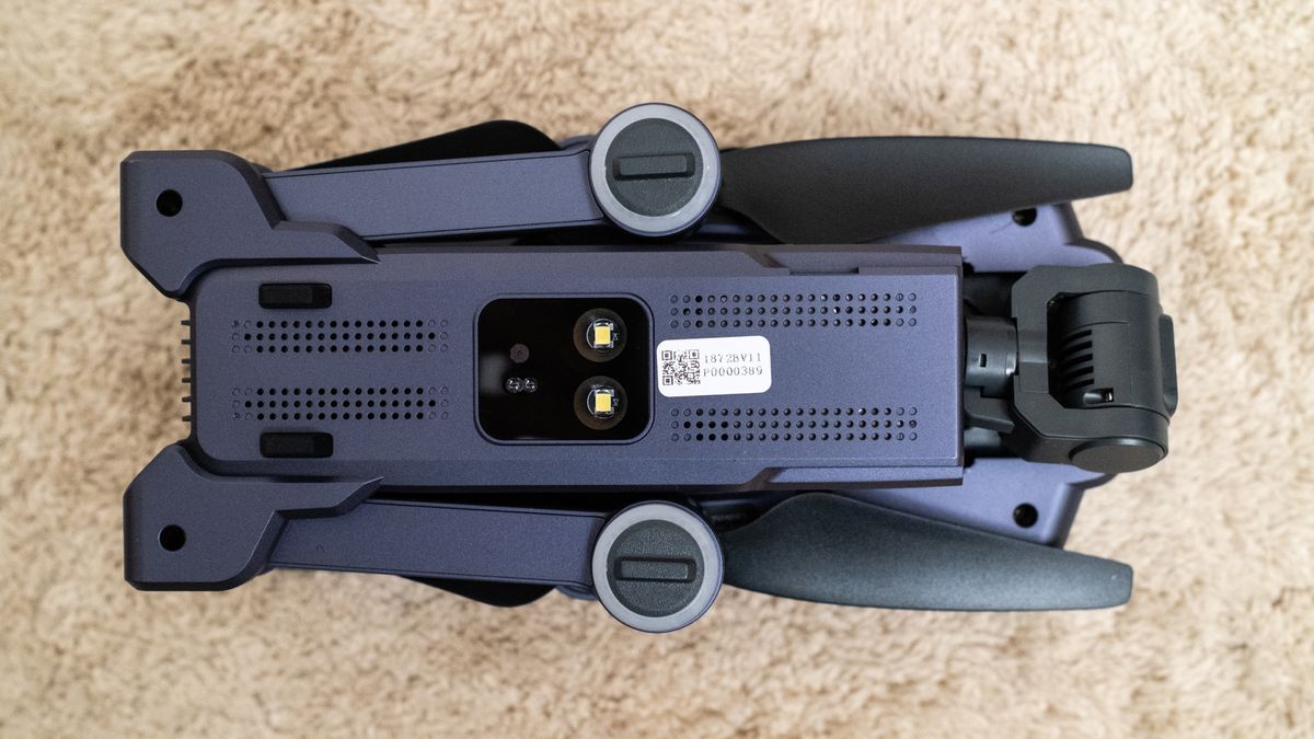 Underneath of a Veeniix V11PRO drone folded on a beige carpet