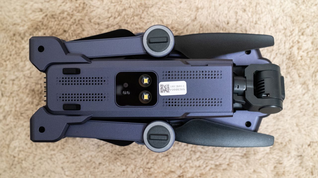 Underneath of a Veeniix V11PRO drone folded on a beige carpet