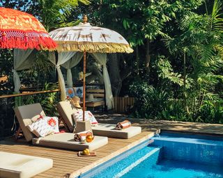 two lounger and boho style parasols on a poolside deck