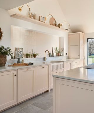 Pink shaker kitchen with brass cabinet knobs