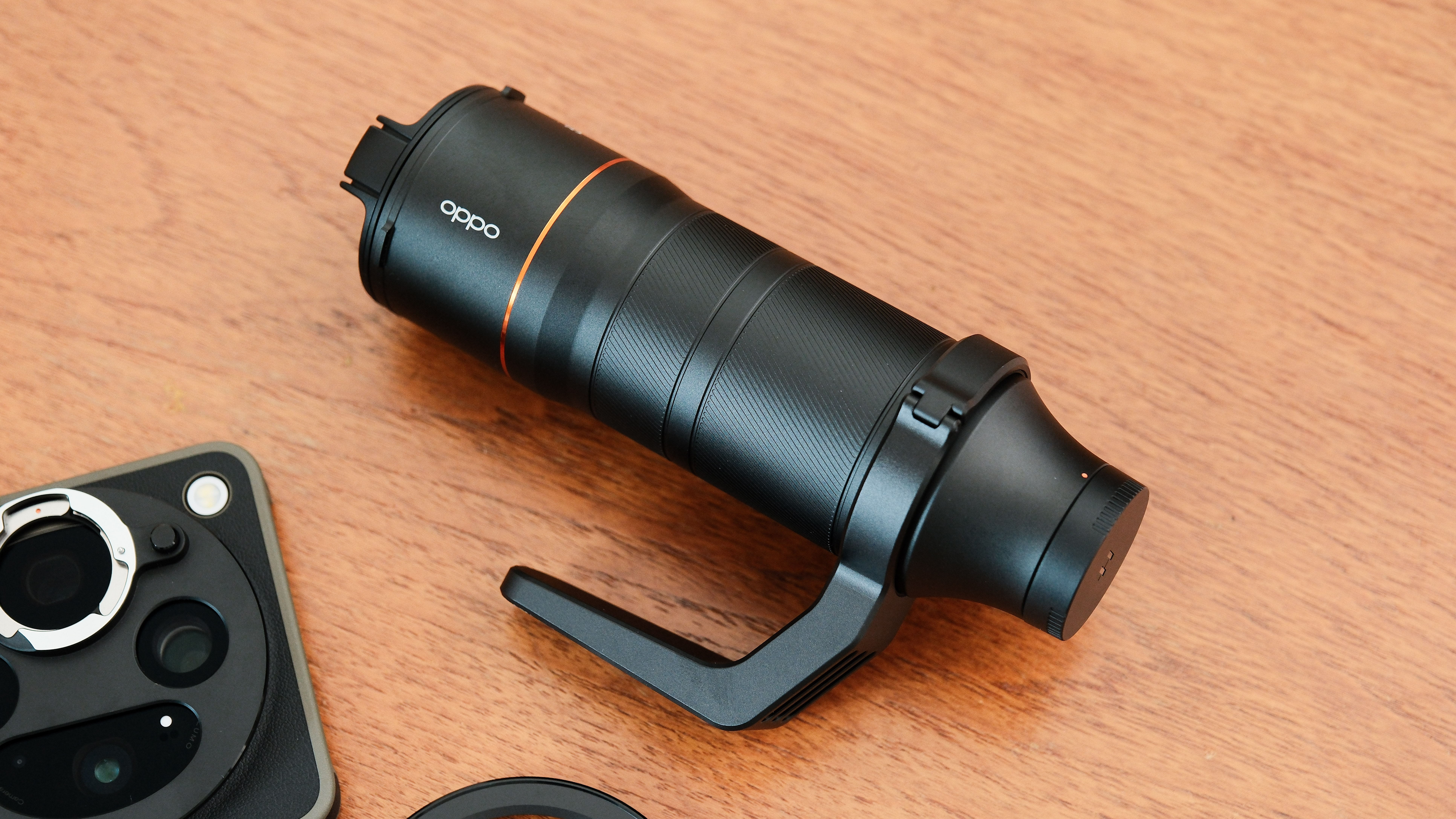 Oppo telephoto accessory lens placed beside the Find X9 Ultra