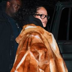 Rihanna in New York City wearing a fur coat with reading glasses and her bottega bag