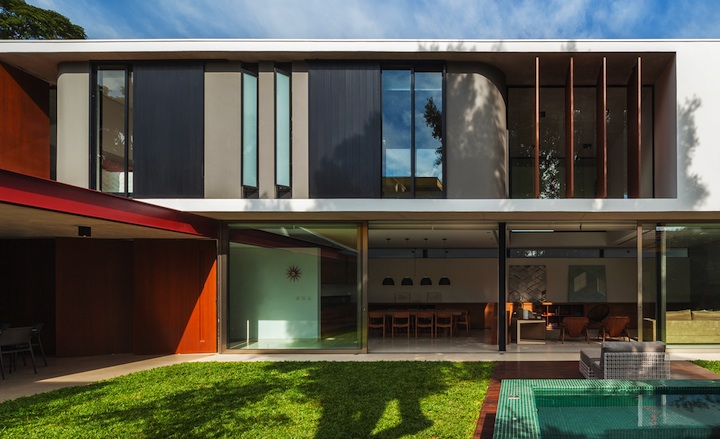 The two volumes - made out of exposed concrete, glass, wood and steel - also define the edges of a manicured grass pavilion, which features a wooden deck extending to a spa