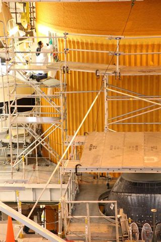 Technicians examine the space shuttle Discovery's external fuel tank in the Vehicle Assembly Building at NASA's Kennedy Space Center in Cape Canaveral, Fla.