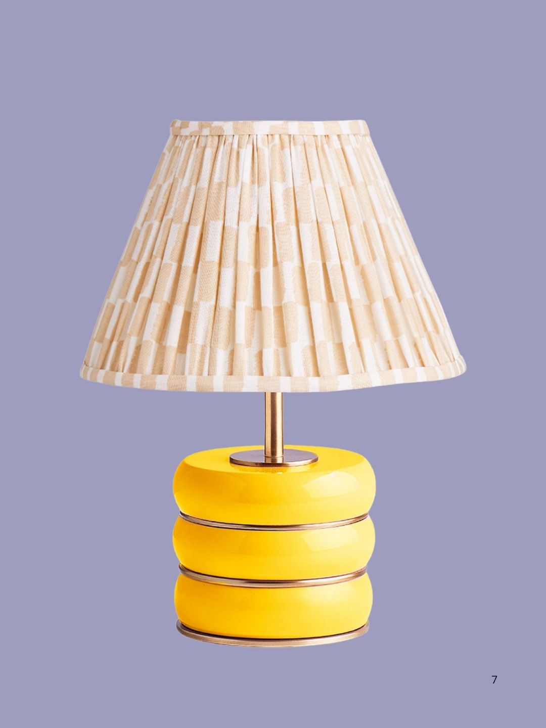 Yellow lamp with a printed blush shade on a dark purple background.