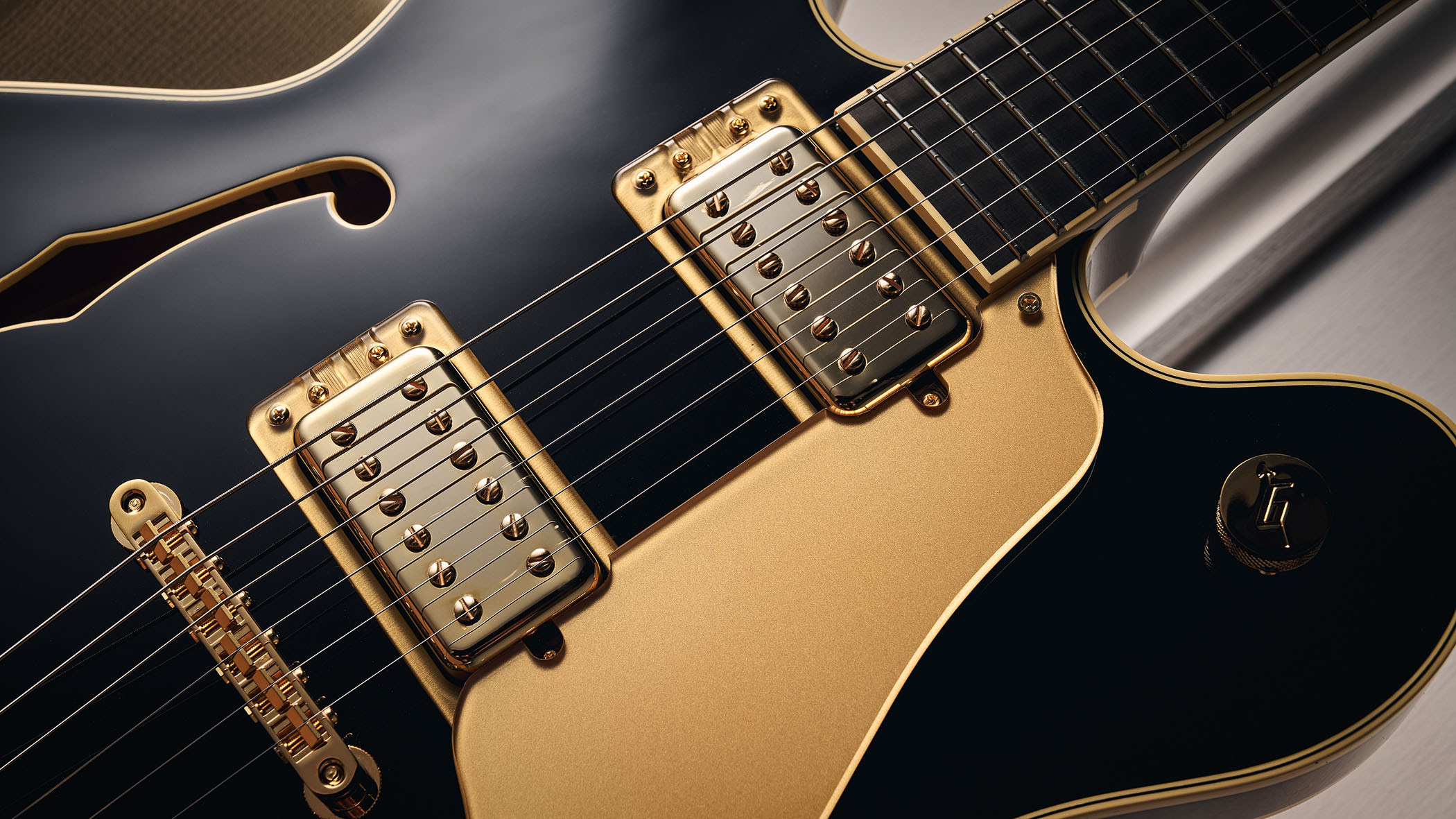 Gretsch Professional Collection Broadkaster LX Center Block: the handsome semi-hollow is finished in black with gold hardware and here is photographed in close-up.
