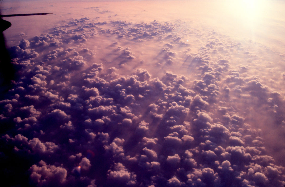 Puffy cumulus illuminated by late afternoon sun far below a NOAA airplane returning to base at after a mission. NOAA flies hurricanes to learn more about how one storm is shaping up and to learn more about the storms in general.