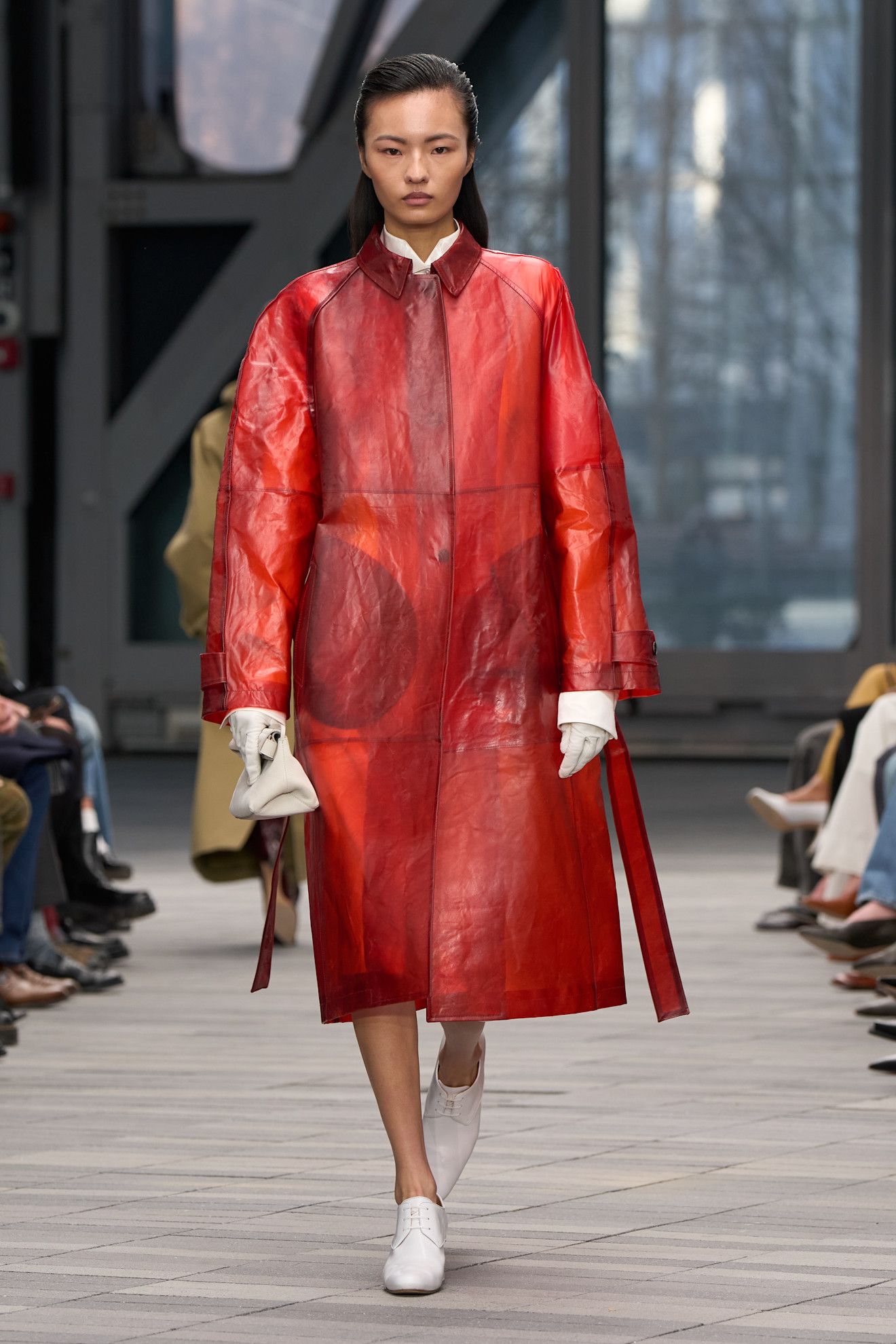 A model wearing a red orange persimmon colored raincoat at Calvin Klein Fall 2026 runway