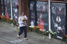 A student places flowers at a memorial following the shooting at UVA. 
