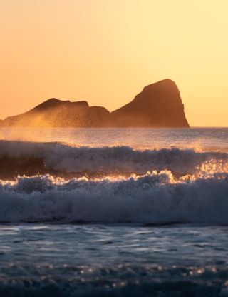 Photo of big crashing waves at sunset.