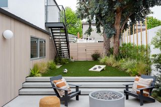 A backyard with plants used to conceal unattractive fencing