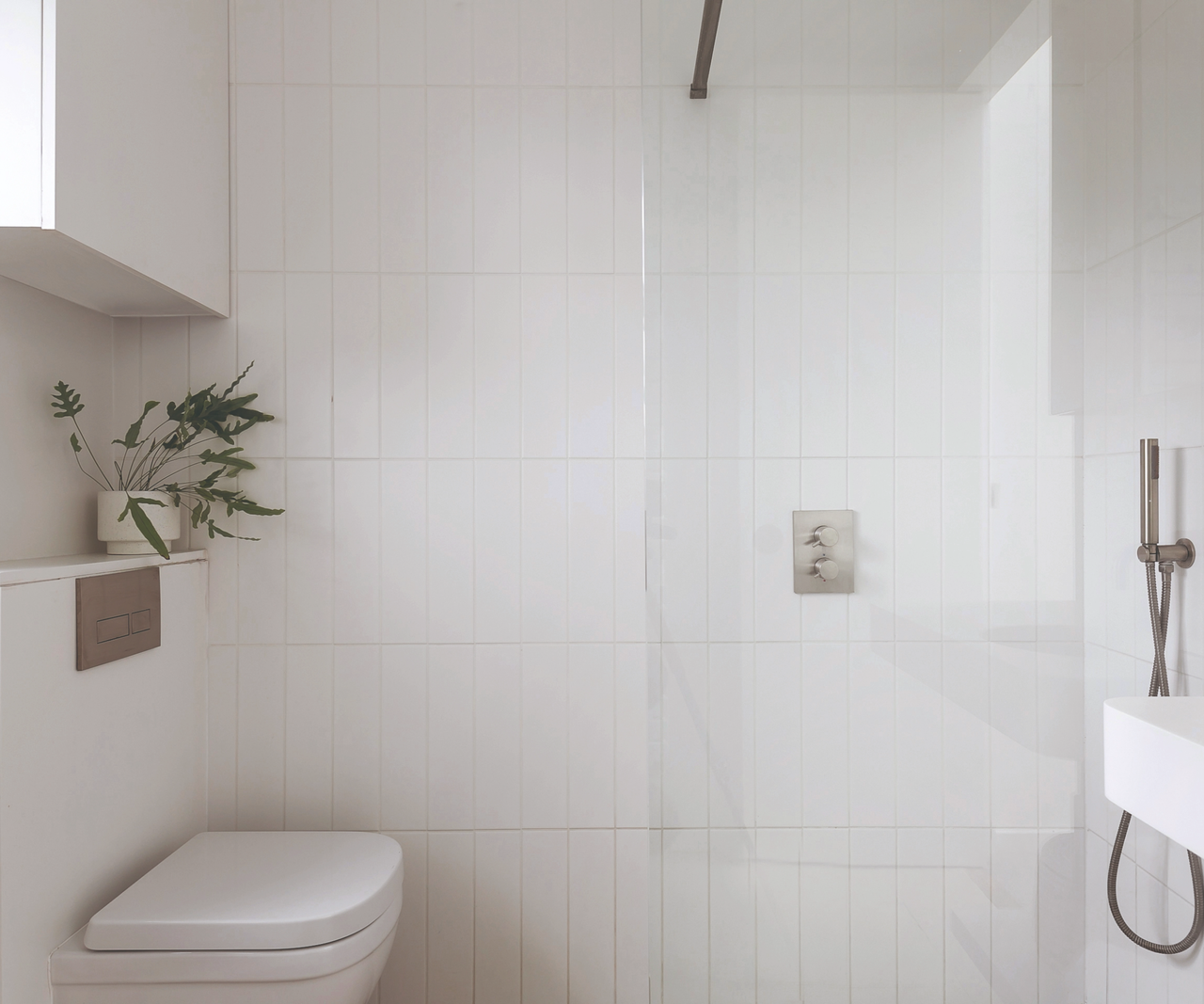 Bathroom facing the shower and toilet and sink