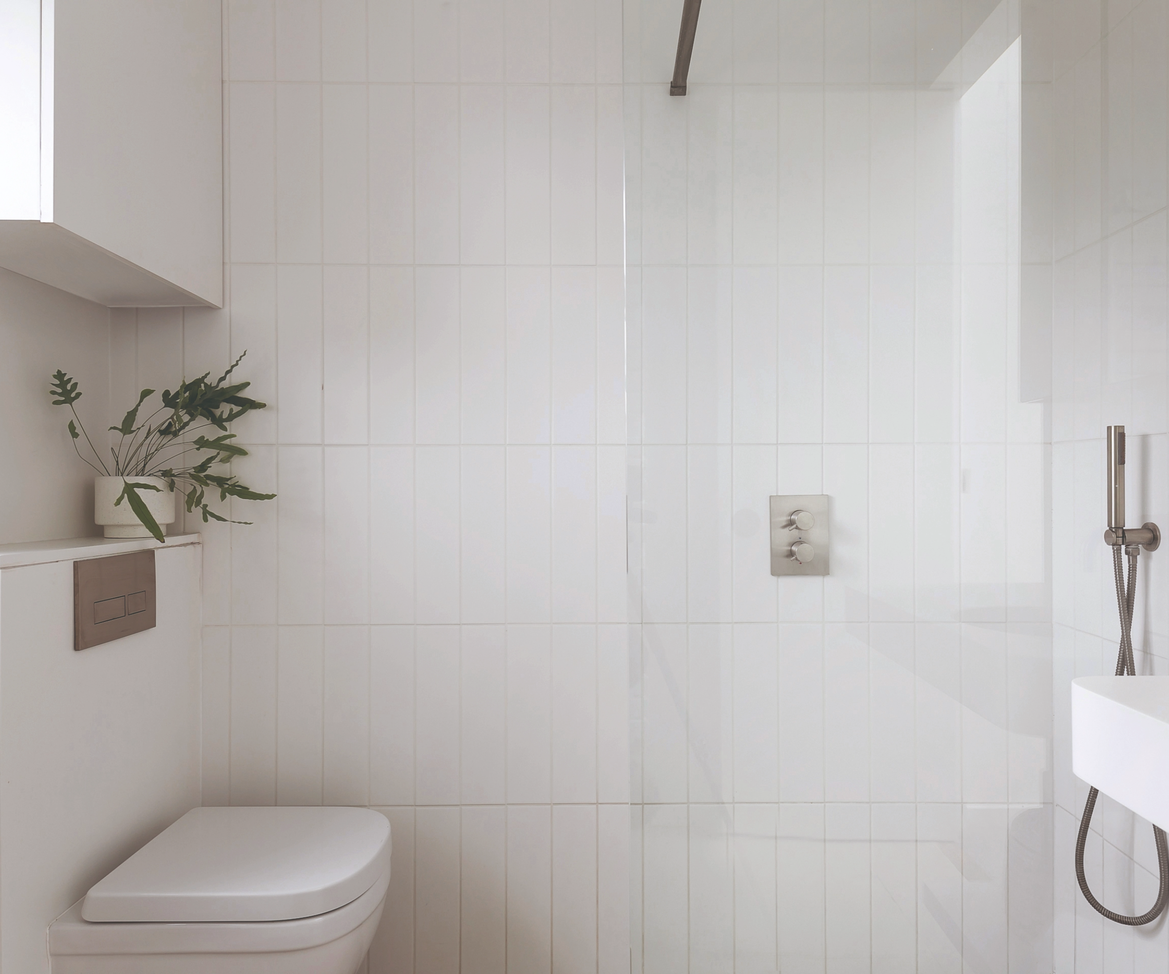Bathroom facing the shower and toilet and sink