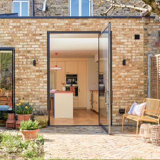 Large glazed door leading out from the kitchen diner to a brick-laid patio