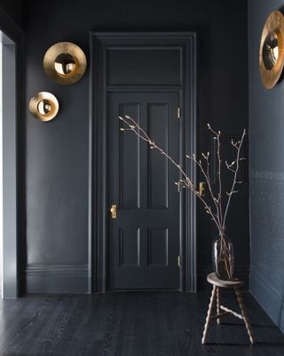 A passageway with dark wooden floor and dark gray doors and walls