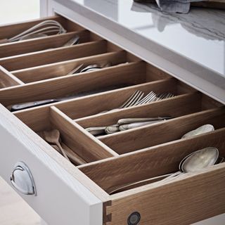 Open kitchen drawer with wooden drawer organiser for cutlery and utensils