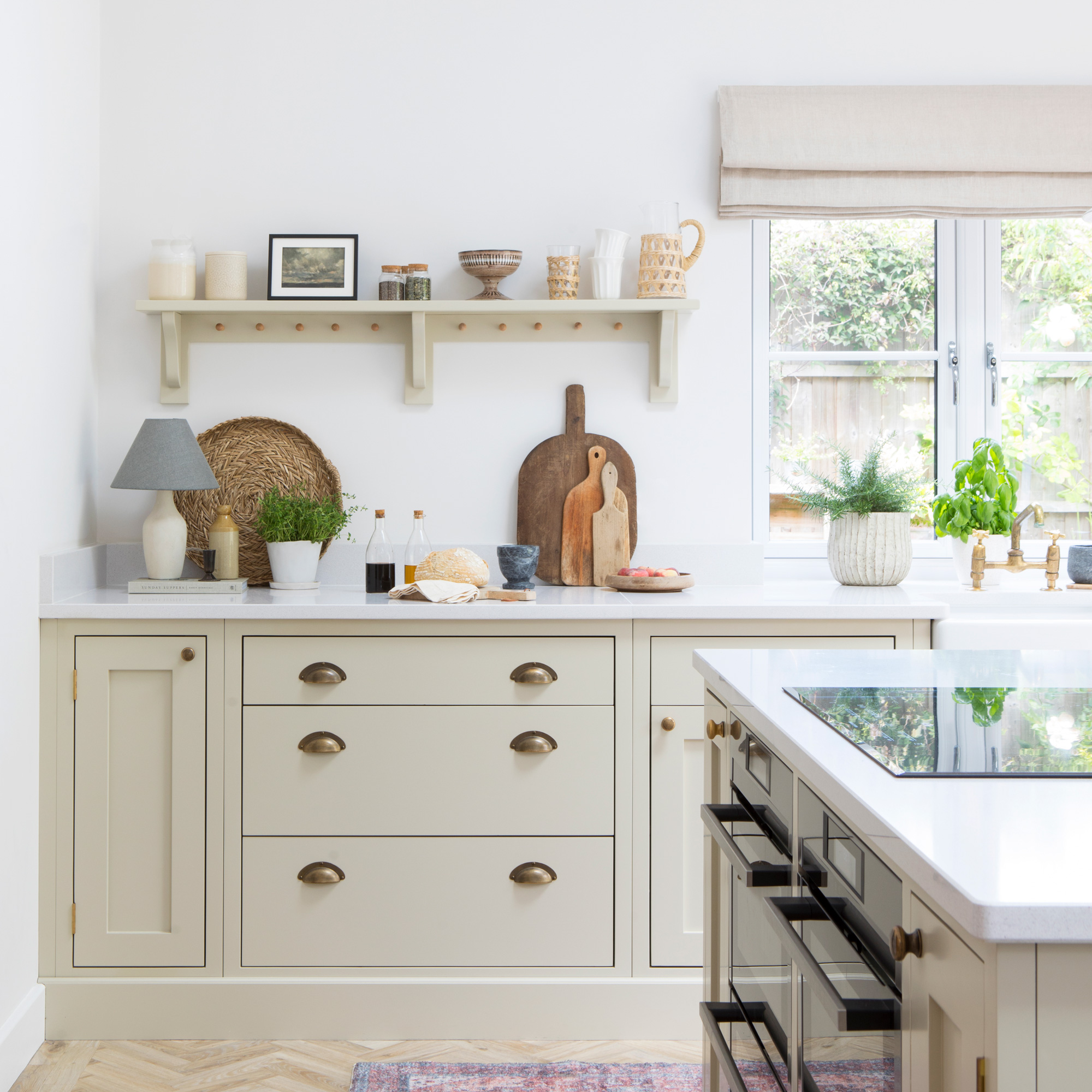 country cottage kitchen with cream coloured shaker cabinets and cup handles, chopping boards and open shelving