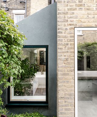 A small pitched roof side return extension with a grey industrial looking render