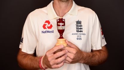 England cricketer holding the Ashes cricket urn