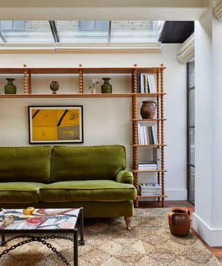 White living room with jute rug, olive sofa and bespoke open shelving unit