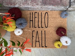 Fall door matt with knitted pumpkins