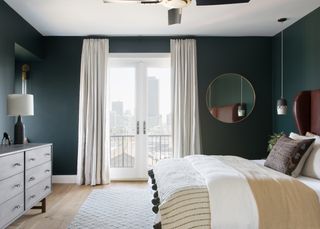 A bedroom with teal walls and earthy bedding