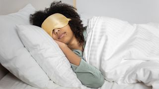 Woman in bed wearing sleep mask