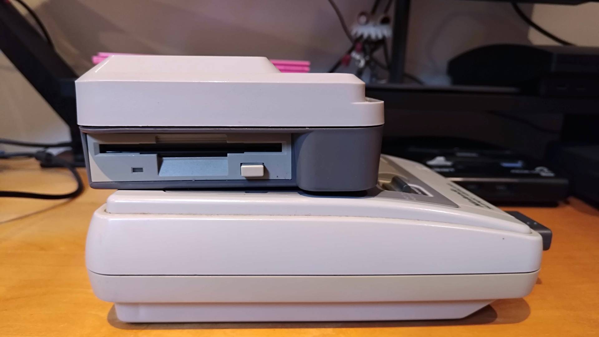 Side view of Super Wild Card connected to Japanese SNES (Super Famicom) with floppy disc drive in view.