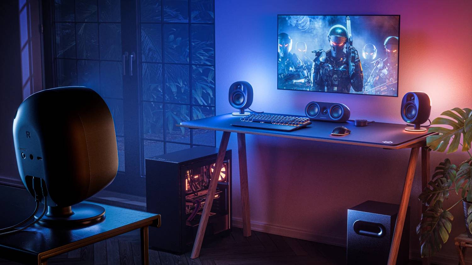PC setup in room with SteelSeries Arena 9 speakers around on tables with RGB lighting
