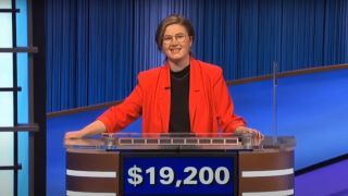 Mattea Roach stands smiling at her podium during Final Jeopardy on Jeopardy Masters.