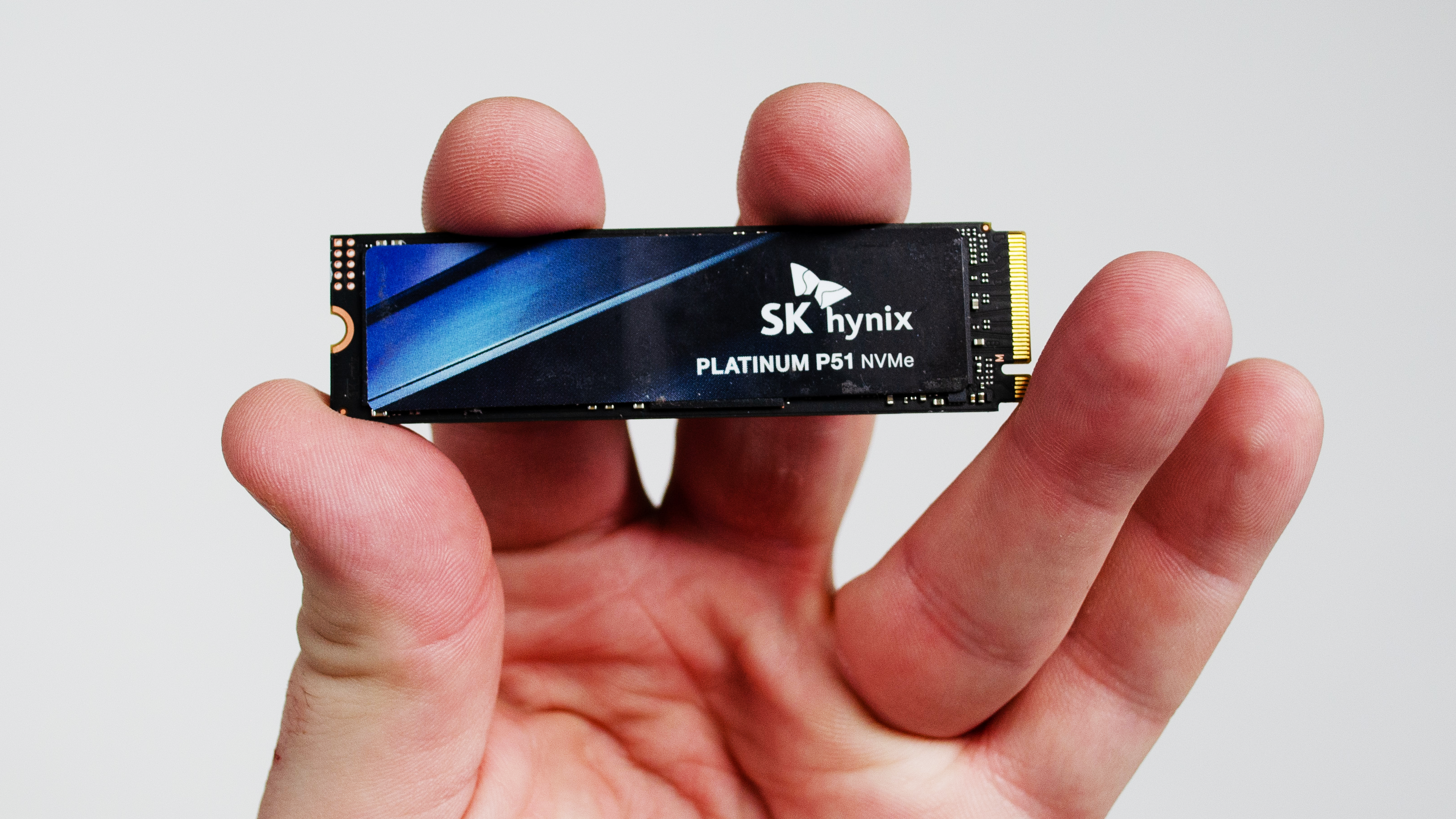 An SK Hynix Platinum P51 SSD held up in a masculine hand