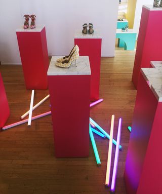 Stilettos and heeled boots surrounded by neon tubing