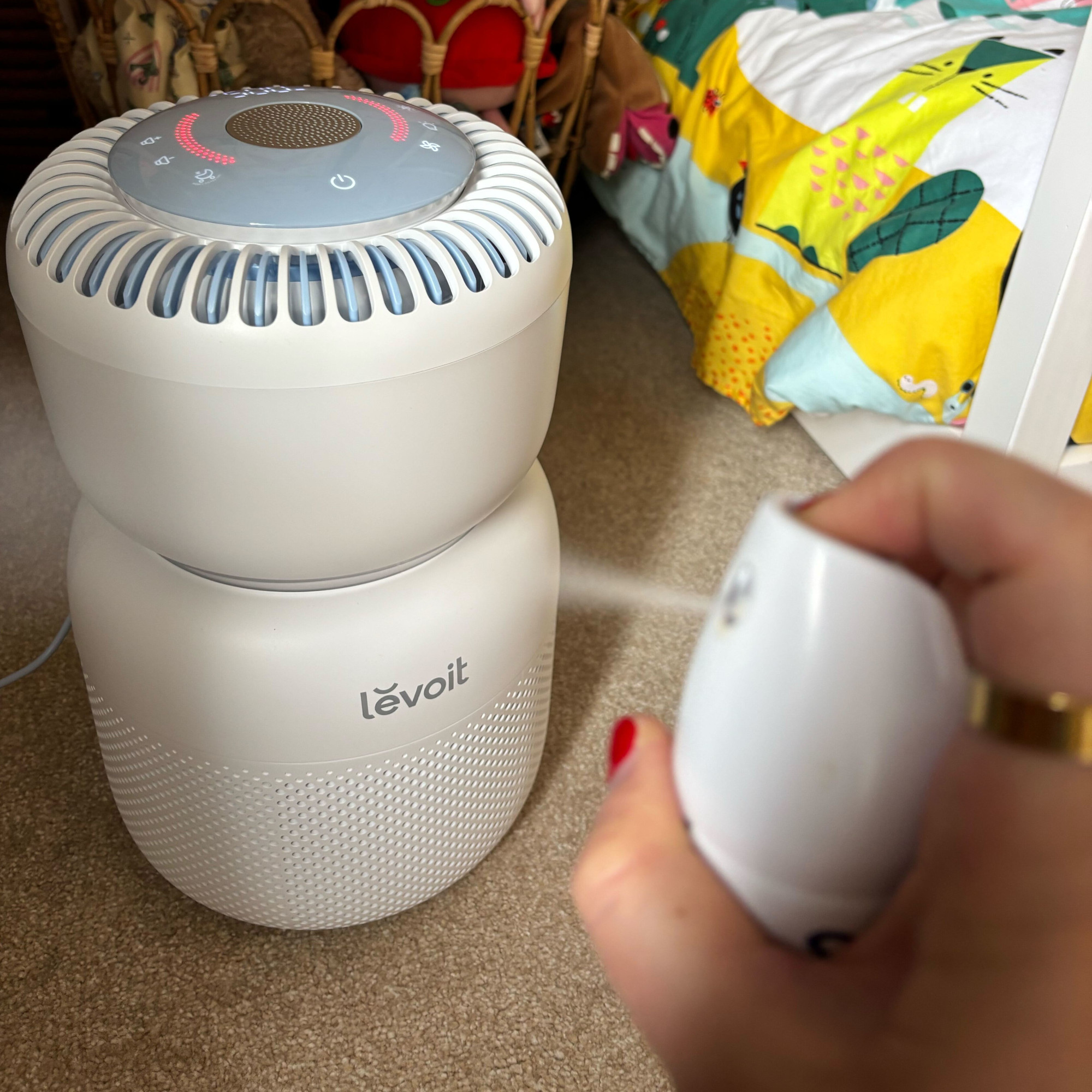 deodorant being sprayed near the levoit sprout air purifier