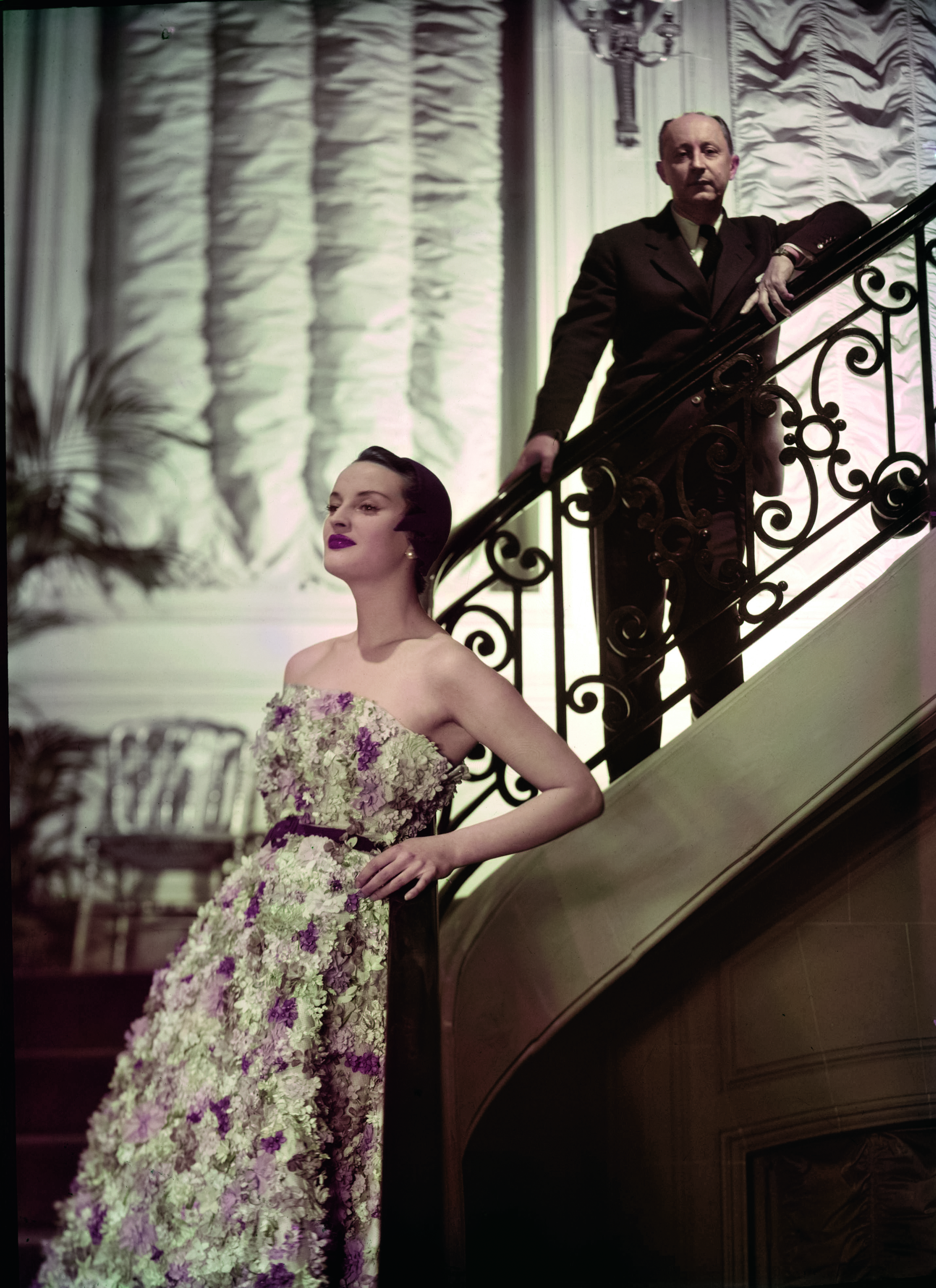 Christian Dior and a model pose on the staircase