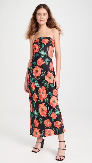 mode wears strapless dress with poppies on it and black heels